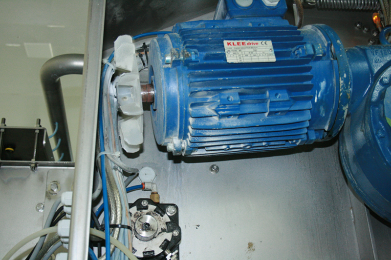 Le garde protecteur du ventilateur de refroidissement du moteur électrique de la motorisation de cet équipement "Goulot" n’a pas été remis en place de sorte que le ventilateur est en train de détruire le câblage informatique (en gris), le tuyau d’air comprimé (en bleu), les câbles de commande (en bleu pâle) et les câbles de contrôle (recouverts d’acier inoxydable tressé). De plus, il y a surchauffe du moteur électrique. Les roulements portent le suffixe C3, ce qui signifie que les roulements DE & NDE (drive end et non drive end) ont un jeu interne plus grand que la normale. Ceci est tout à fait correct, car, lorsque le moteur a atteint sa température de fonctionnement, comme le rotor est plus chaud que le stator qui lui est normalement refroidi par l’air pulsé par le ventilateur, les jeux mécaniques dans les roulements redeviennent normaux, car la couronne intérieure des roulements est plus chaude que les couronnes extérieures. Dans notre cas, le jeu interne reste plus grand que la normale, car le stator n’est pas refroidi, ce qui entraîne une vibration parasite qui va détruire les roulements et possiblement le moteur considérant qu’il est haute efficacité et que dans ce cas, la distance entre le rotor et le stator est réduite. 